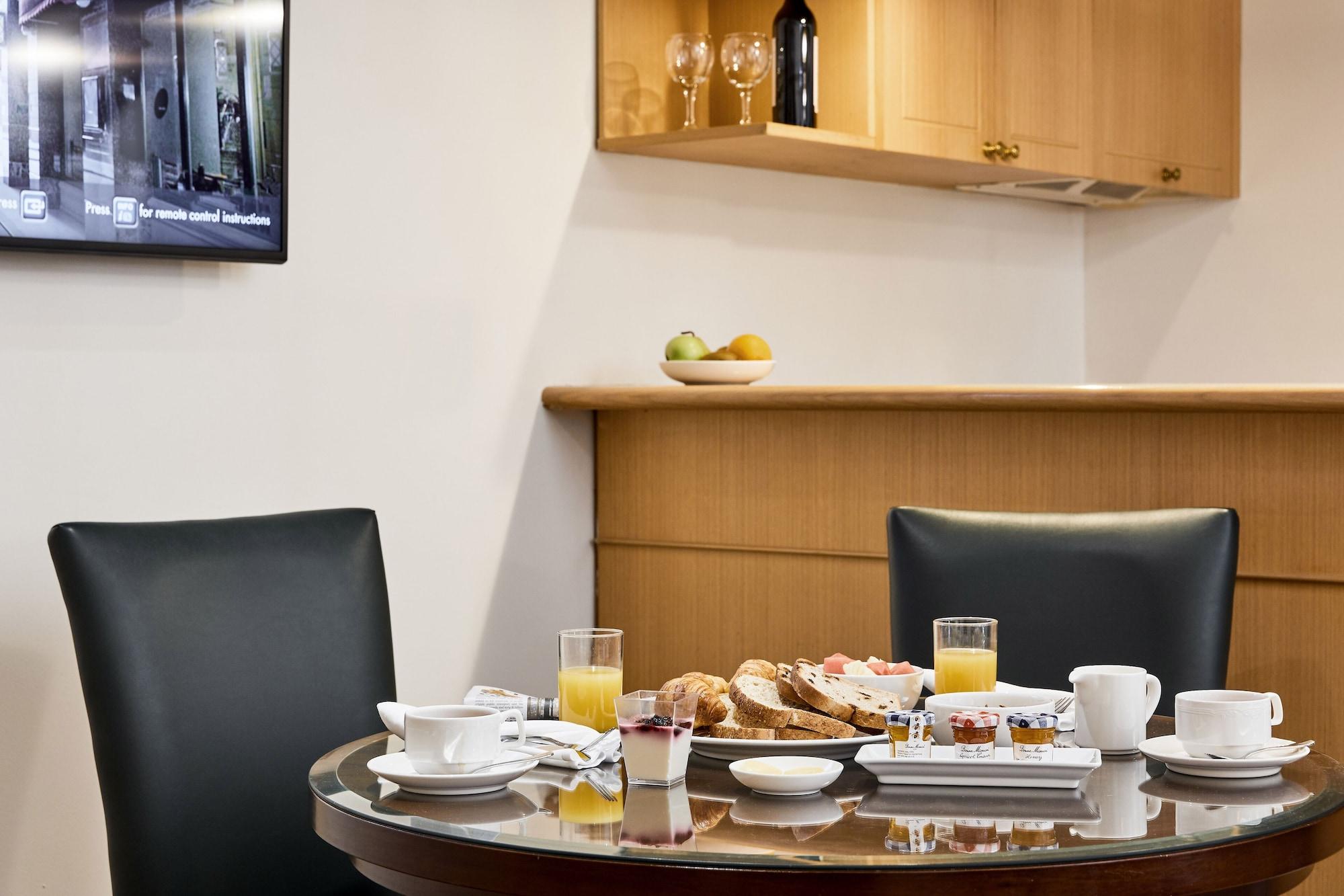 Stamford Plaza Melbourne Hotel Ngoại thất bức ảnh The photo shows a dining table set for breakfast or brunch. There are several food items displayed, including pastries and bread. Additionally, there are drinks, such as orange juice, served in glasses, and coffee in white cups. The table is round an