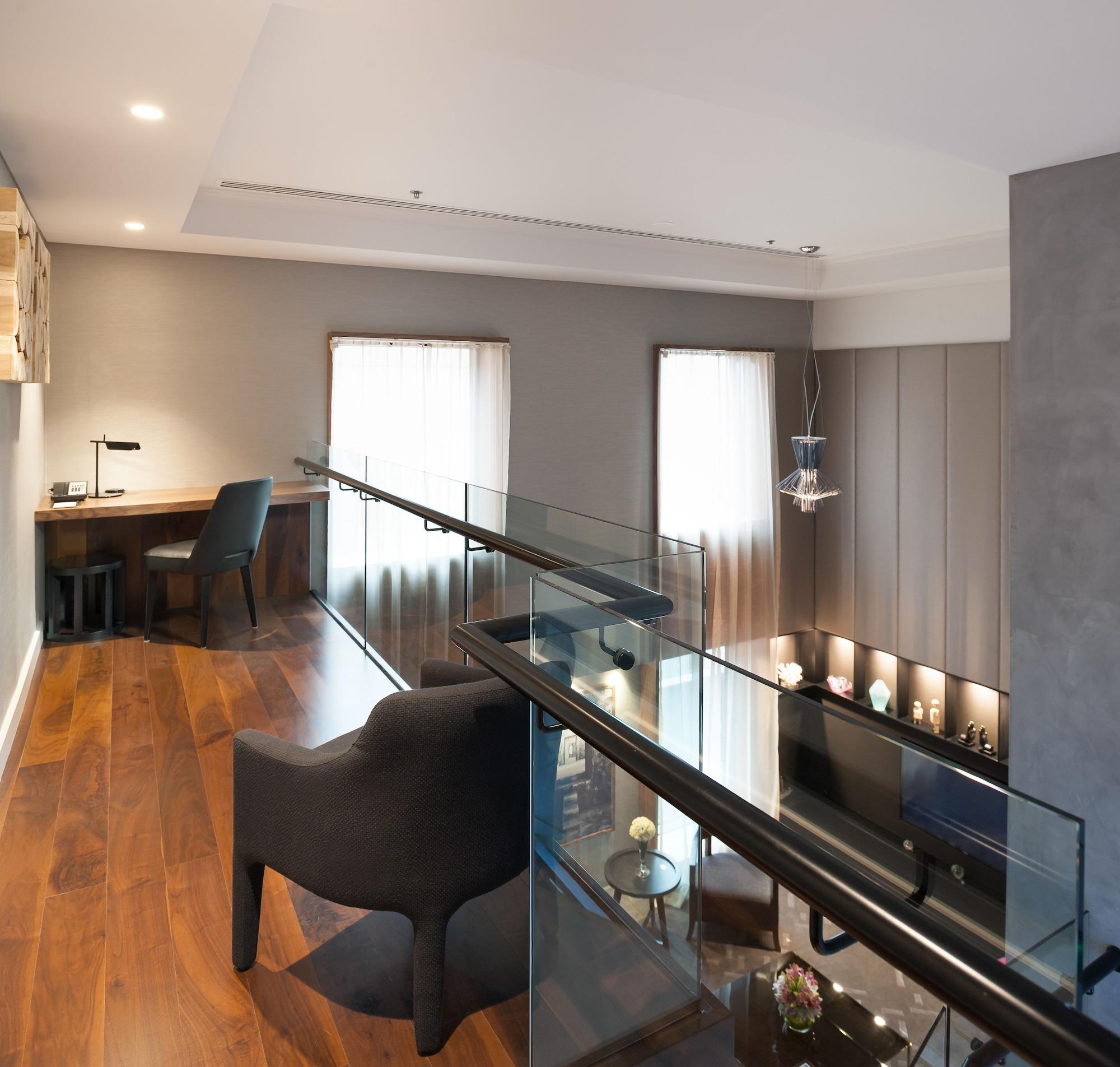 Stamford Plaza Melbourne Hotel Ngoại thất bức ảnh The photo shows a modern interior space, featuring a second-floor balcony overlooking a lower level. The decor is stylish and minimalistic, with a combination of wooden flooring and neutral-colored walls. 

On the upper level, there is a small desk a