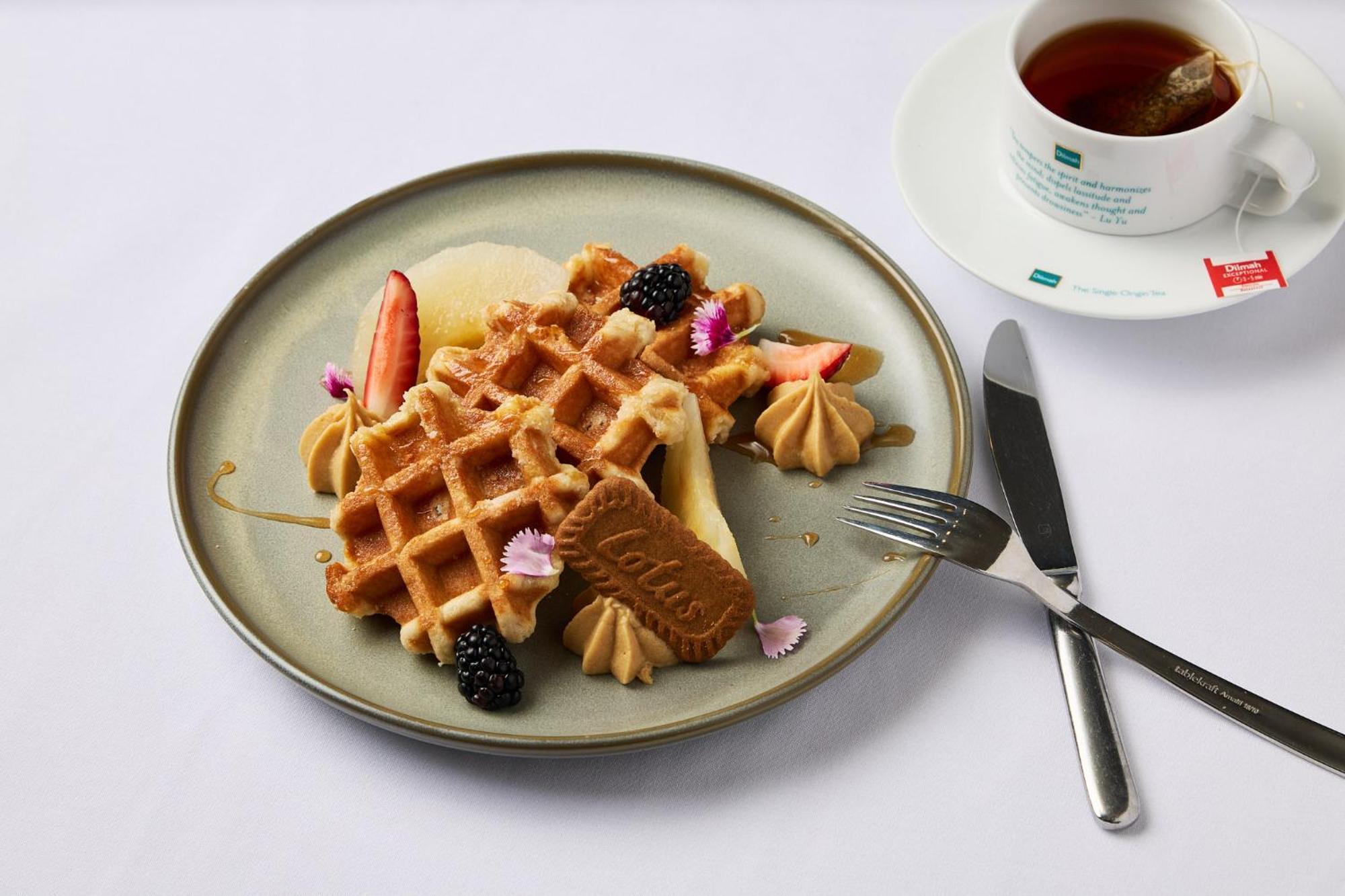 Stamford Plaza Melbourne Hotel Ngoại thất bức ảnh The photo depicts a beautifully arranged plate of waffles. The waffles are topped with a variety of accompaniments including slices of fresh fruit, blackberries, and small dollops of cream or mousse. A decorative cookie is placed on the waffles, addi