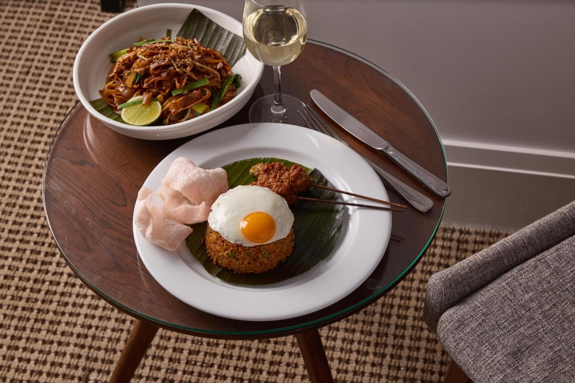 Stamford Plaza Melbourne Hotel Ngoại thất bức ảnh The photo shows a beautifully arranged meal on a wooden side table. On a white plate, there is a serving of fried rice, topped with a sunny-side-up egg, accompanied by prawn crackers. The dish also features a small portion of what appears to be a spi